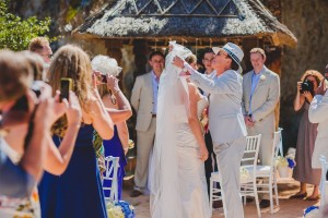 Father lifting brides wedding viel on Ibiza beach