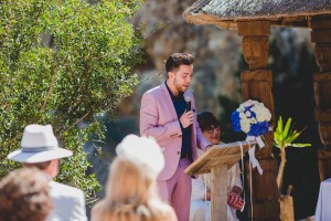 Natural portrait of the brides brother reading during beach ceremony