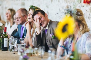 Groom laughing at wedding speeches