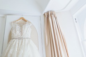 Short fit and flare wedding dress hung on wardrobe