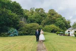 Bride walking through garden with dad