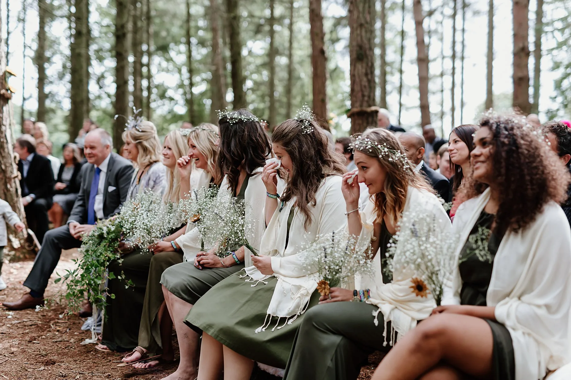 Bridesmaids crying during a woodland wedding ceremony.