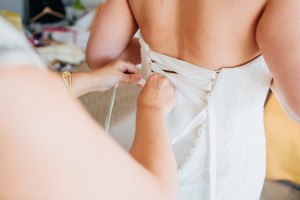 Mother of the bride lacing up the wedding dress