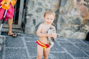 Natural portrait of child holding kitten, Italy
