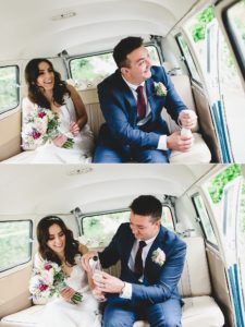 Bride and groom drinking champagne in VW campervan