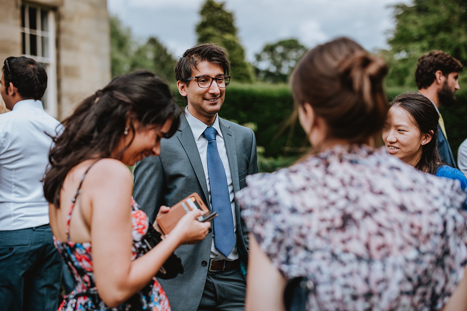 Wedding guests chatting during the drinks reception at Saltmarshe Hall.