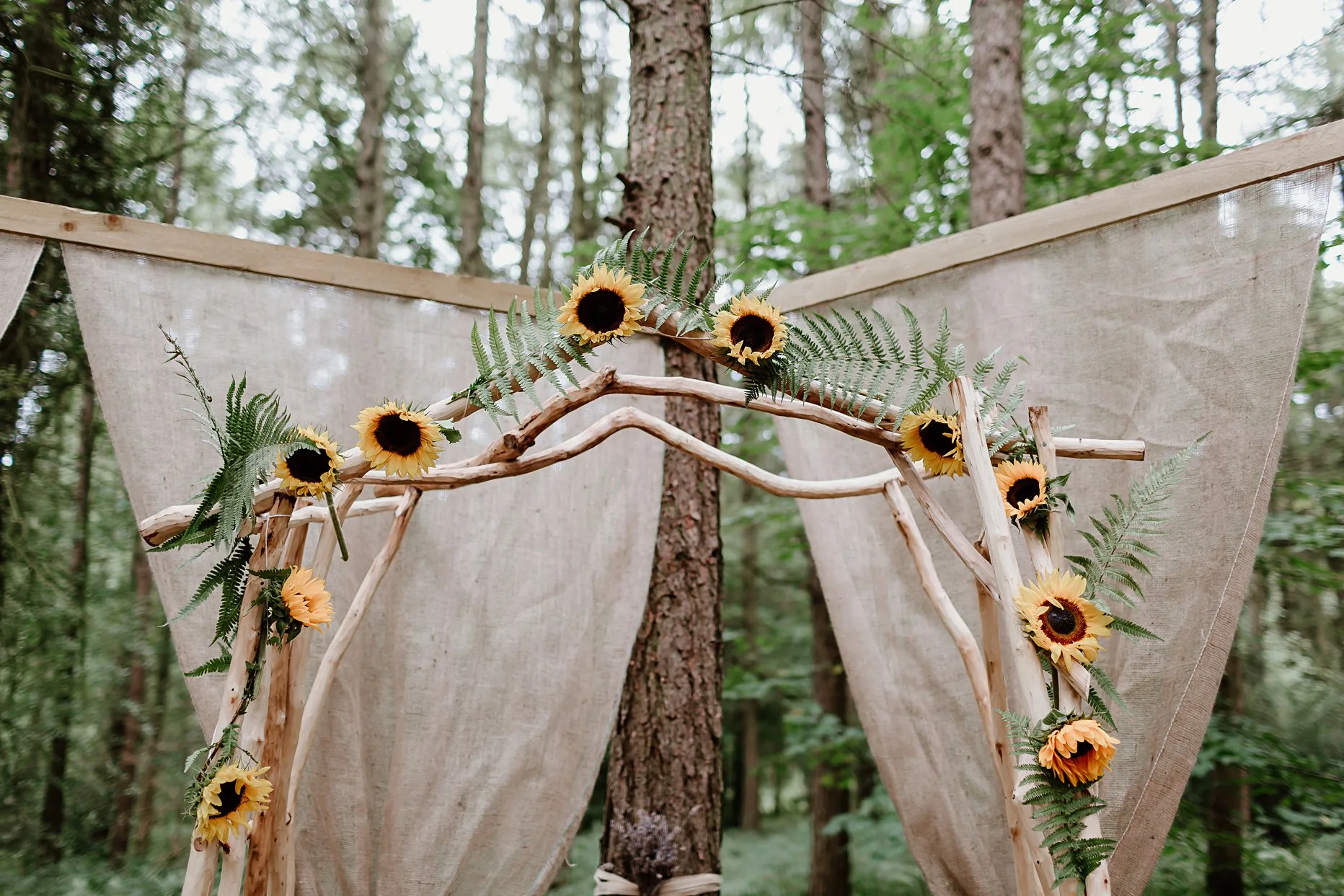 A sunflower archway at the top of the ceremony aisle. Ceremony is outdoors at Camp Katur Wedding venue.