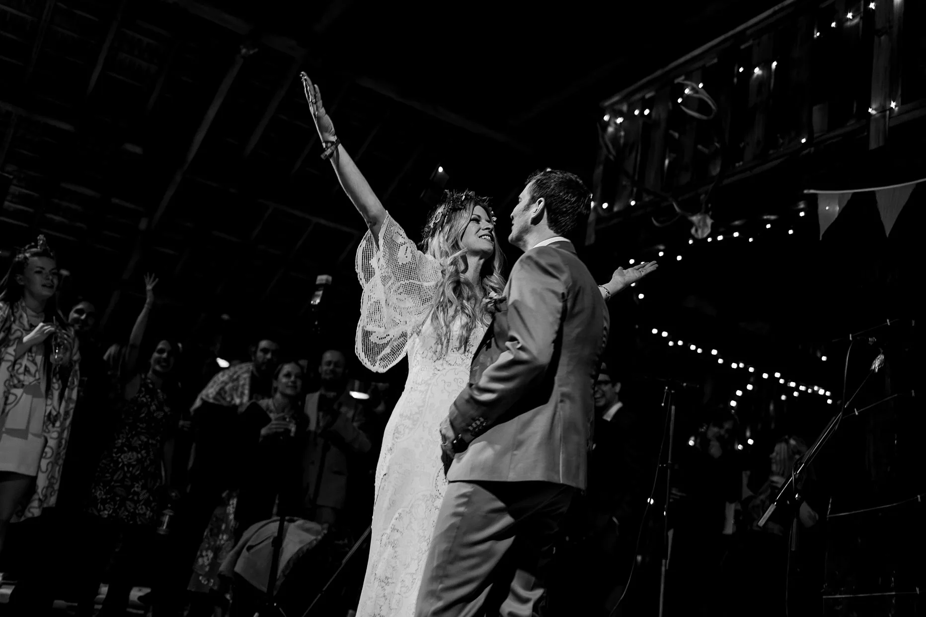 Bride and groom enjoying their first dance together to a heavy metal song. Bride has her arms in the air and is facing her husband smiling.