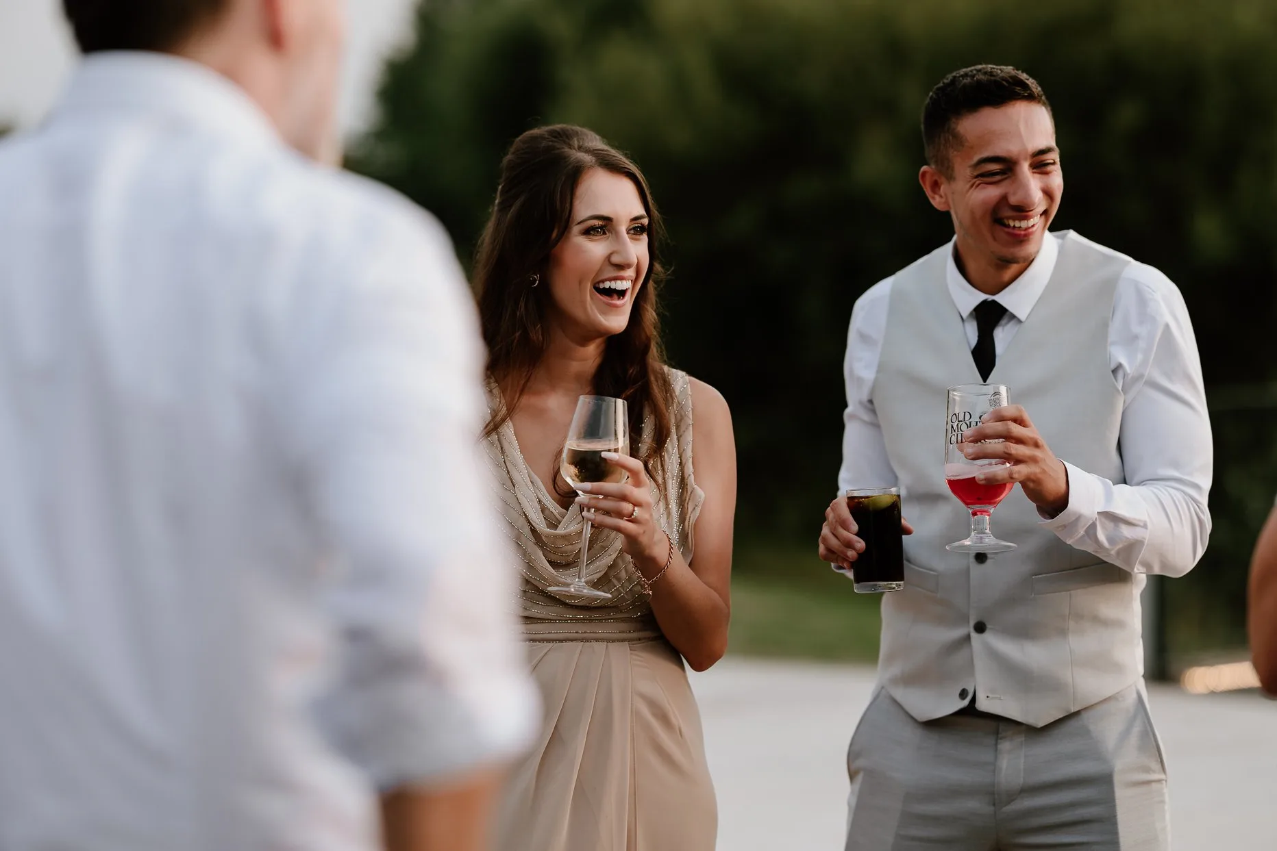 Natural photograph of two wedding guests laughing and smiling.