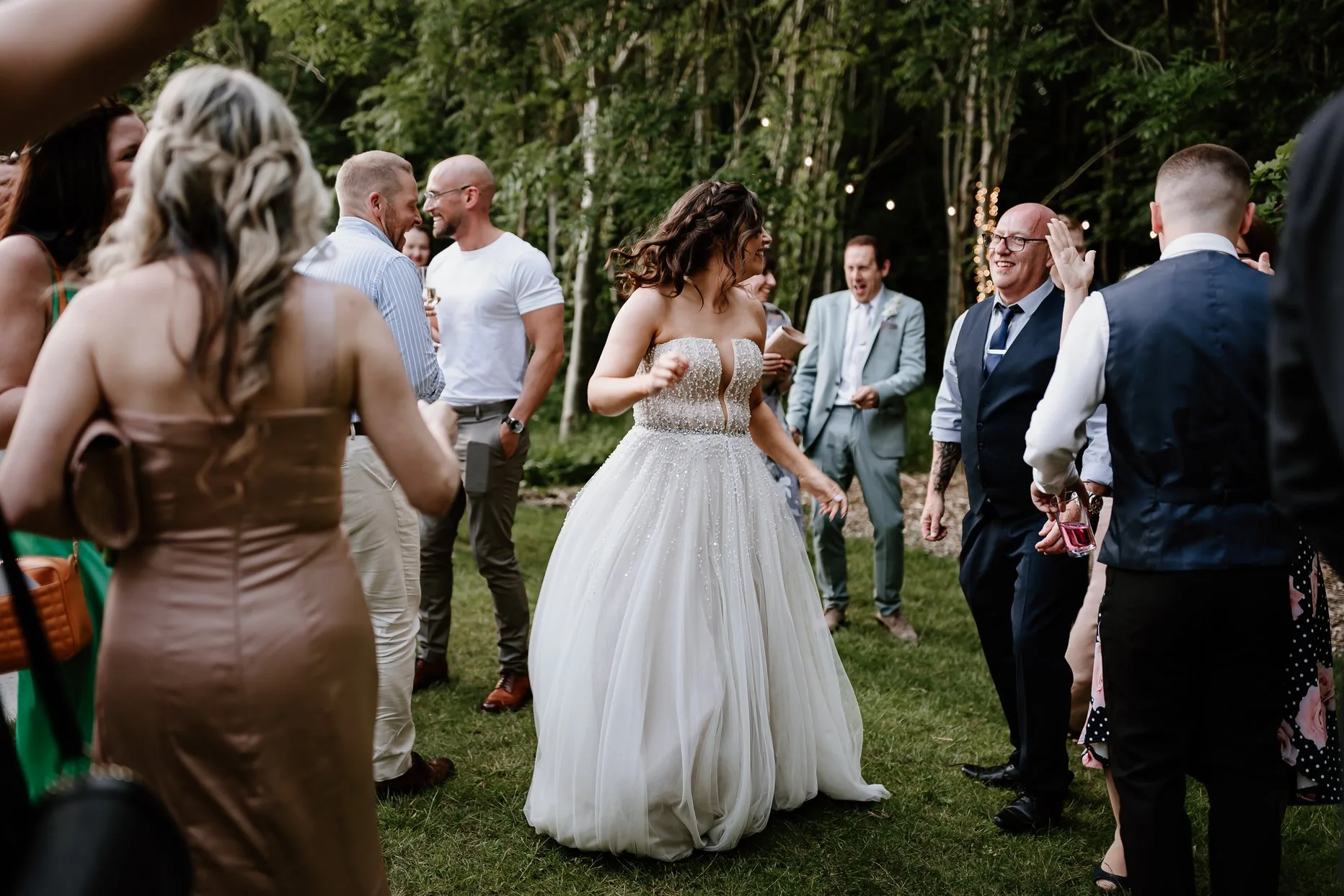 Bride dancing in the woods with her wedding guests after the first dance at Oaklands wedding venue.
