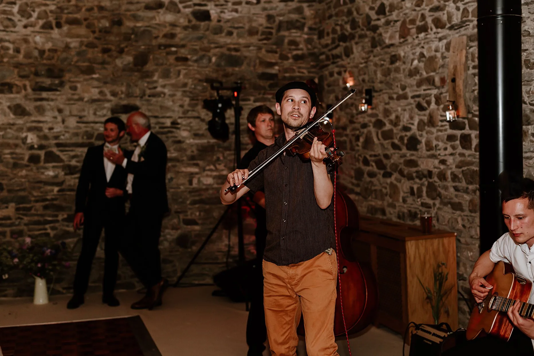 Wedding musician playing violin in a wedding barn in the Lake District.